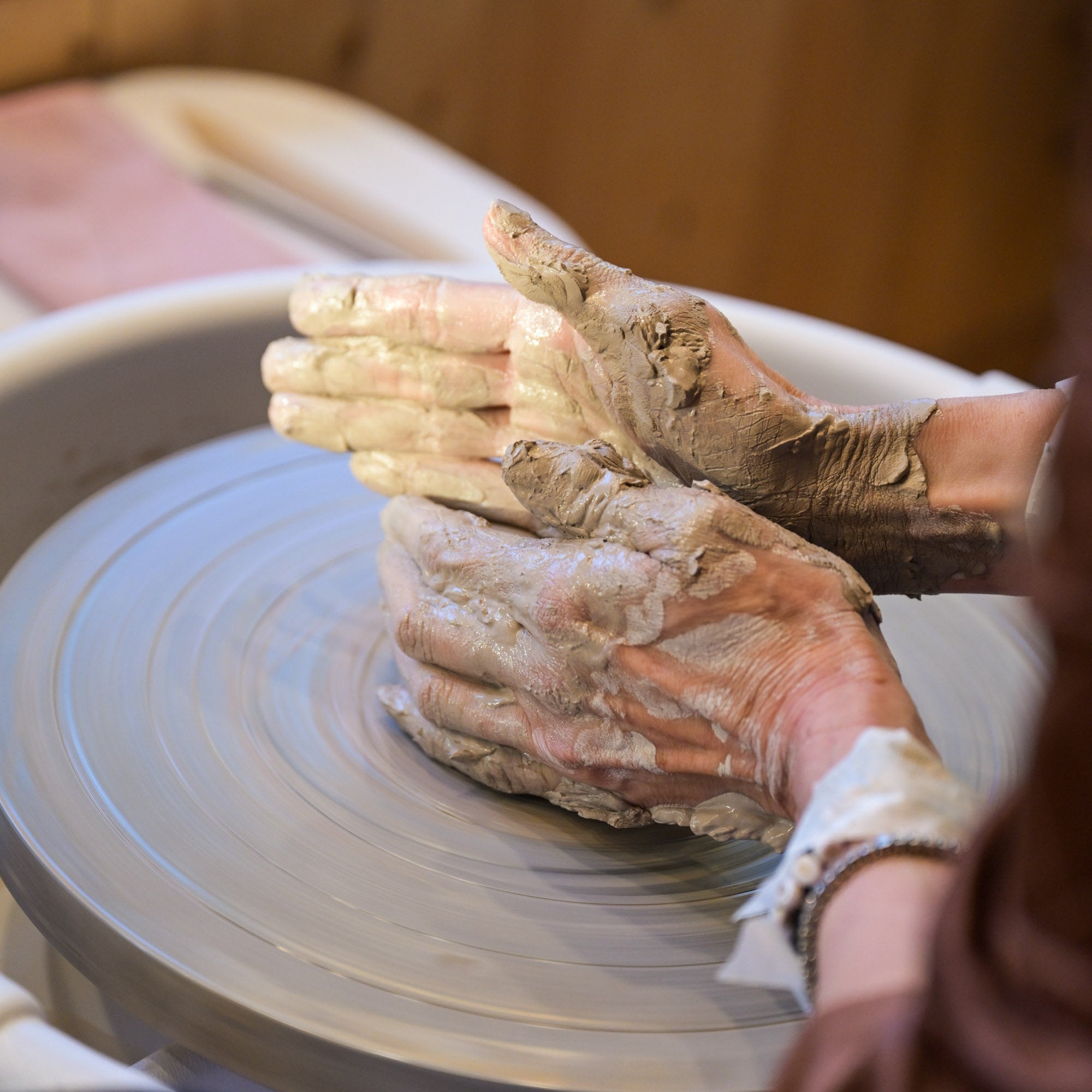hands working with clay on a pottery wheel
